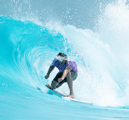 Surfer crouched inside a breaking wave